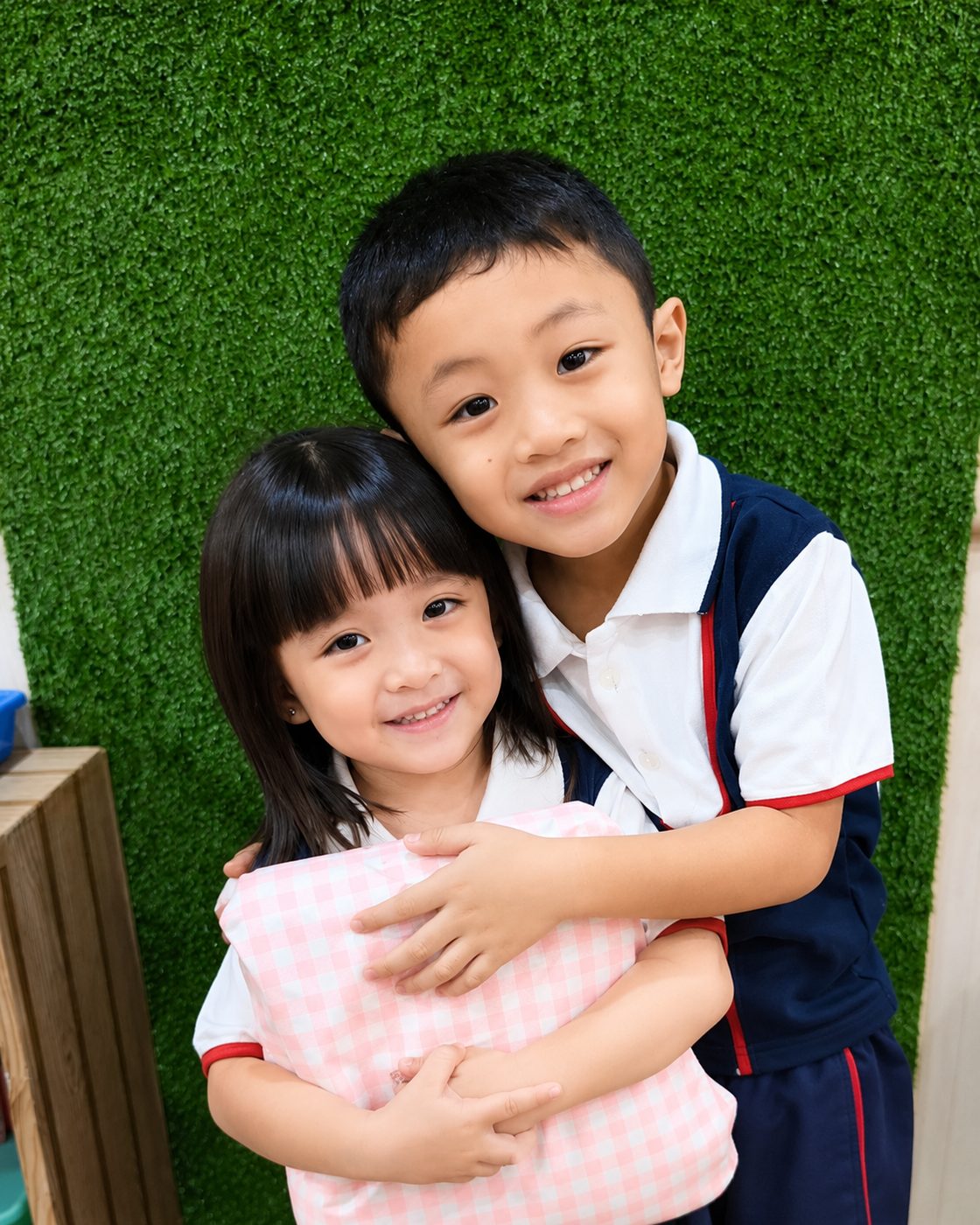 An older child hugging a younger one